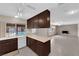 Traditional kitchen with dark cabinets, tile floors and view of backyard pool at 3690 S Rosecrest Cir, Las Vegas, NV 89121