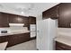 Traditional kitchen features dark wood cabinets, white appliances, and ceiling fan at 3690 S Rosecrest Cir, Las Vegas, NV 89121