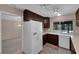 Kitchen features dark wood cabinets and white appliances at 3690 S Rosecrest Cir, Las Vegas, NV 89121