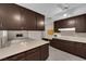 Open kitchen featuring dark wood cabinets, neutral counters, and view of the living room at 3690 S Rosecrest Cir, Las Vegas, NV 89121