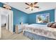 Blue-walled bedroom with a ceiling fan, plush bedding, and an open doorway to a walk-in closet at 952 Contadero Pl, Las Vegas, NV 89138