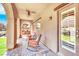 Inviting covered patio with ceiling fan, brick pavers, rocking chairs and outdoor dining in the meticulously landscaped backyard at 952 Contadero Pl, Las Vegas, NV 89138