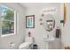 Bathroom with white fixtures, pedestal sink, and natural light from a window overlooking greenery at 716 Solitude Point Ave, Henderson, NV 89012
