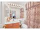 Traditional bathroom with framed mirror, wood vanity, and patterned shower curtain at 716 Solitude Point Ave, Henderson, NV 89012