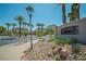 Community entrance with palm trees, lush landscaping, and clear blue skies on a sunny day at 716 Solitude Point Ave, Henderson, NV 89012
