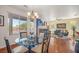 Well-lit dining room featuring a glass table, chandelier, and fireplace with views of the outdoors at 716 Solitude Point Ave, Henderson, NV 89012