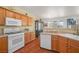 Kitchen with white appliances, wood cabinetry, and tile flooring at 716 Solitude Point Ave, Henderson, NV 89012