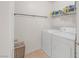 Functional laundry room equipped with a washer, dryer, overhead shelving, and neutral flooring at 716 Solitude Point Ave, Henderson, NV 89012