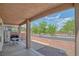 Comfortable covered patio with seating and a view of the landscaped backyard and surrounding area at 716 Solitude Point Ave, Henderson, NV 89012