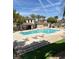 Community pool with several lounge chairs, tables, and a covered patio with ample seating at 716 Solitude Point Ave, Henderson, NV 89012