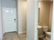 Bright entryway featuring tile flooring, a white front door, and a convenient half-bathroom at 8279 Palladium St, Las Vegas, NV 89113