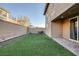 Artificial turf backyard with covered patio and block wall at 356 Espressivo St, Henderson, NV 89011