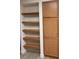 Wood-toned shelving and cabinetry in a kitchen pantry at 9580 W Reno Ave # 114, Las Vegas, NV 89148