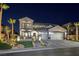 Elegant two-story home with a three-car garage, manicured landscaping, and a charming water feature at night at 2781 Josephine Dr, Henderson, NV 89044