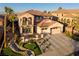 Stunning two-story home with a tile roof, lush landscaping, palm trees, and a charming water feature in the front yard at 2781 Josephine Dr, Henderson, NV 89044