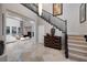 Spacious foyer featuring a staircase, stylish console table, and views into the living room with plush white sofas at 2781 Josephine Dr, Henderson, NV 89044