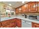 Kitchen with wood cabinets, tile flooring, and a window to a small patio at 123 Fir St, Henderson, NV 89015