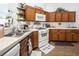 Well-equipped kitchen featuring wood cabinets and white appliances at 2525 Kirkmichael Ln, Henderson, NV 89014