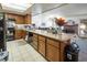 Open kitchen with granite island, wooden cabinets, and black appliances at 3544 Sandcliff Ln, Las Vegas, NV 89121