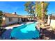 Backyard swimming pool featuring desert landscaping and an outdoor kitchen area at 3544 Sandcliff Ln, Las Vegas, NV 89121