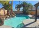Backyard swimming pool features a rock waterfall, palm trees, and a concrete deck for outdoor enjoyment at 3544 Sandcliff Ln, Las Vegas, NV 89121