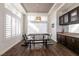 Bright dining room featuring stylish light fixture, wood floors, and a large window with plantation shutters at 913 Pro Players Dr, Las Vegas, NV 89134
