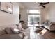 Bright living room with hardwood floors, dual sofas, large windows, and access to a patio at 913 Pro Players Dr, Las Vegas, NV 89134