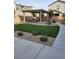 A well-maintained backyard features a covered patio, artificial grass, and rock landscaping at 10205 Starlit Canyon Ct, Las Vegas, NV 89141