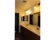 Bathroom with double vanity, lighted mirrors, and dark wood cabinets at 117 Logan Pond Way, North Las Vegas, NV 89084