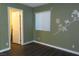 Bedroom with green walls, wood-look floors, and access to bathroom at 117 Logan Pond Way, North Las Vegas, NV 89084