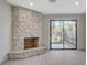 Stone fireplace with access to backyard through sliding glass doors at 3012 Plaza De Rosa, Las Vegas, NV 89102