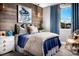 Bright bedroom with wood-like wall, comfy bed, and window views at 10363 Vista Argento Ave, Las Vegas, NV 89166