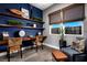 Home office with floating shelves, wood desk, and comfy seating at 10363 Vista Argento Ave, Las Vegas, NV 89166