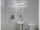 Small bathroom with pedestal sink, oval mirror, and light-colored walls at 4132 Spring Storm Ave, North Las Vegas, NV 89081