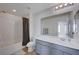 Clean bathroom boasts a bathtub, toilet and vanity with modern gray cabinets at 4132 Spring Storm Ave, North Las Vegas, NV 89081
