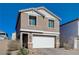 Two-story house with a white garage door and landscaping at 4132 Spring Storm Ave, North Las Vegas, NV 89081