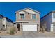 Two-story house with a white garage door and landscaping at 4132 Spring Storm Ave, North Las Vegas, NV 89081