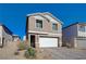 Two-story house with a white garage door and landscaping at 4132 Spring Storm Ave, North Las Vegas, NV 89081