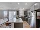 Open kitchen boasts gray cabinets, granite island, and stainless steel appliances at 4132 Spring Storm Ave, North Las Vegas, NV 89081