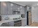 Modern kitchen with gray cabinets, granite countertops, and stainless steel appliances at 4132 Spring Storm Ave, North Las Vegas, NV 89081