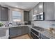 Gray cabinets, granite countertops, and stainless steel appliances in this kitchen at 4132 Spring Storm Ave, North Las Vegas, NV 89081