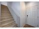Beige carpeted staircase with white railing and door at 4132 Spring Storm Ave, North Las Vegas, NV 89081