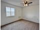 Cozy bedroom with neutral carpeting, ceiling fan, and a window view at 2510 N Woodchips Rd, Pahrump, NV 89060