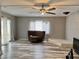 Spacious living room with wood floors, ceiling fan, and natural light from sliding glass door at 2510 N Woodchips Rd, Pahrump, NV 89060