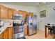 Kitchen with wood cabinets, stainless steel appliances, and a dining area at 4690 E Utah Ave, Las Vegas, NV 89104