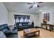 Living room featuring hardwood floors, leather sofas, and a ceiling fan at 4690 E Utah Ave, Las Vegas, NV 89104