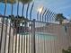 Glimpse of the sparkling community pool through a decorative fence, surrounded by palm trees and clear blue skies at 2521 Sierra Luna Ave # 106, Las Vegas, NV 89106