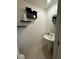 Clean and modern half bathroom with pedestal sink and floating shelves at 2609 Via Napoli, Henderson, NV 89044