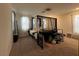 Spacious bedroom with canopy bed, large windows, and carpeted floor at 2609 Via Napoli, Henderson, NV 89044