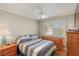 Comfortable bedroom with ceiling fan, carpeted floor, dresser, and view from window at 8737 Autumn Valley Ave, Las Vegas, NV 89129